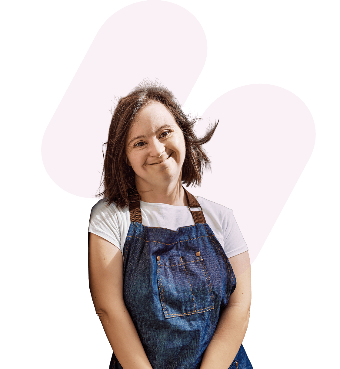 Smiling woman in a denim apron standing against a purple background.